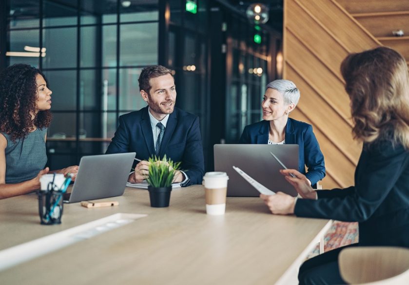 Smartly-dressed finance professionals talking in a meeting room
